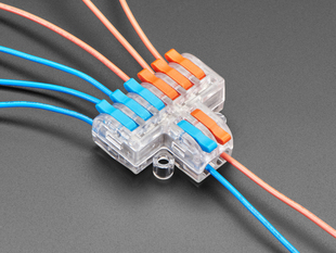 Angled shot of clear 2-to-6 Wiring Block Connector assembled with blue and red wires.