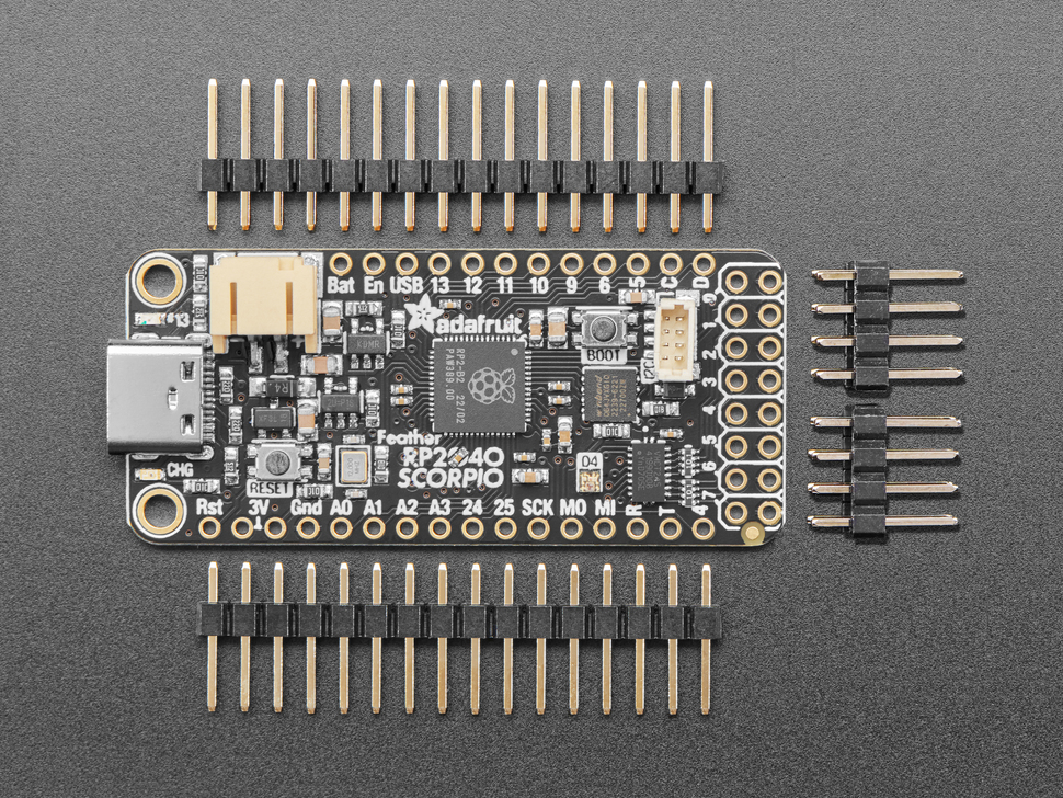 Overhead shot of rectangular microcontroller next to two pieces of 16-pin header and two 2x4 headers.