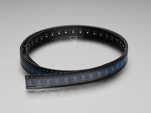 Angled shot of a black reel strip containing IC chips.