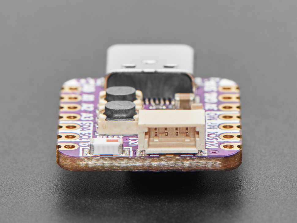 Close-up of STEMMA QT connector on purple, square-shaped microcontroller.