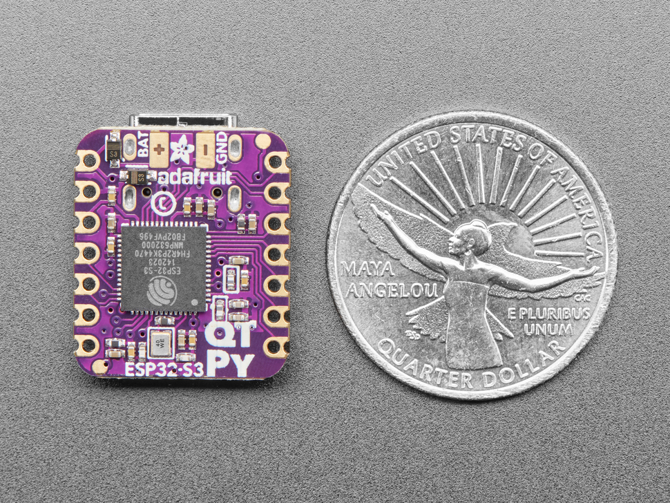 Back of small purple, square-shaped microcontroller next to US quarter for scale.