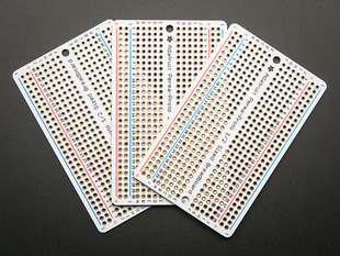 Top view of three fanned out Adafruit Perma-Proto Half-sized Breadboard PCBs.