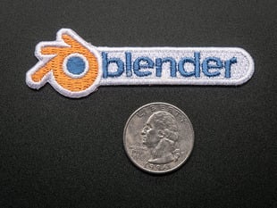 Embroidered badge in the shape of blender logo, with orange spinning wheel and the word BLENDER in blue on a white background. Shown next to a quarter for scale. 