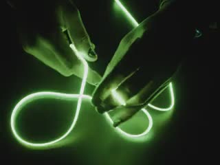 Additional video of Black hands playing with a long piece of green LED filament.