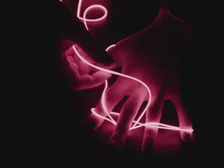 Additional video of Black hands playing with a 1.2m long LED filament string glowing red LEDs.