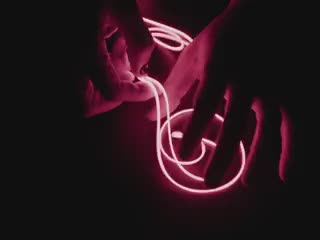 Video of Black hands playing with a 1.2m long LED filament string glowing red LEDs.