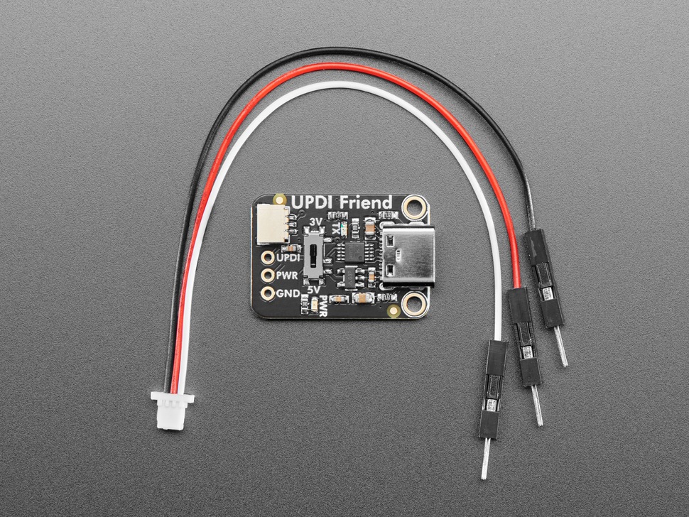 Overhead shot of black, rectangular UPDI friend board with a mini JST cable.