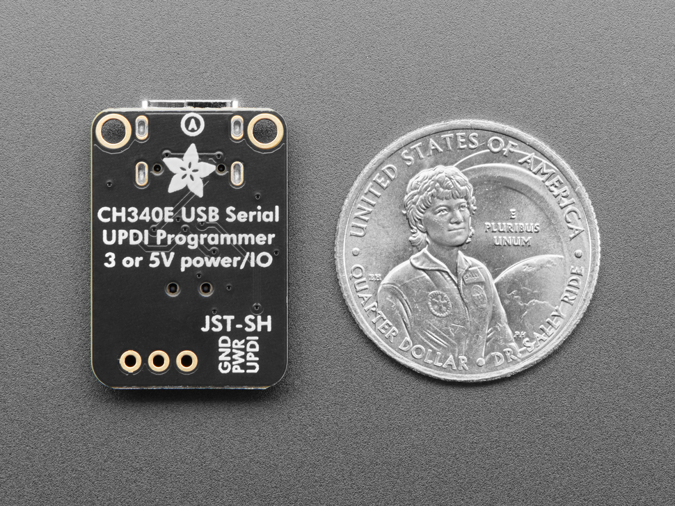 Back of black, rectangular UPDI friend board next to US quarter for scale.