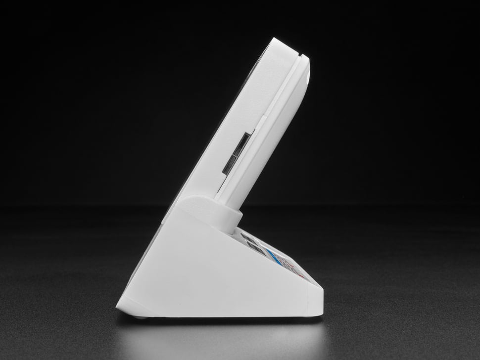Right side of white, square-shaped IoT display device on a white plastic dock.