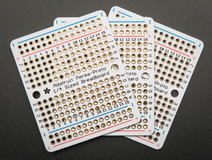 Top view of three fanned out Adafruit Perma-Proto Quarter-sized Breadboard PCBs.