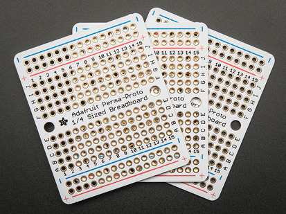 Top view of three fanned out Adafruit Perma-Proto Quarter-sized Breadboard PCBs.