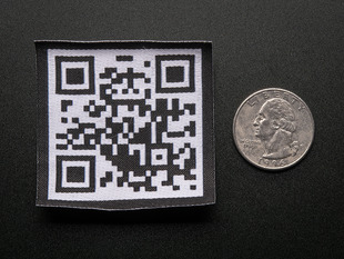 Square embroidered badge with a QR code in black on a white background, with black trimming. Shown next to a quarter for scale. 