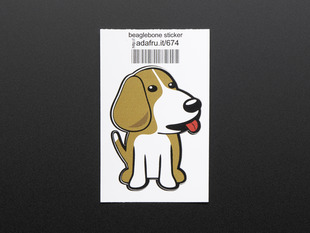 Sticker in the shape of sitting BeagleBone dog logo. Dog is brown and white with red detail for tongue. Mounted on white paper with barcode. 