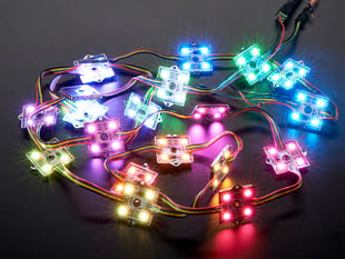 Cluster of many lit up LED pixel squares on wire strand, rainbow colored