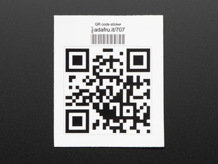 Square sticker with a QR code in black on a white background, with black trimming. Mounted on white paper with barcode. 