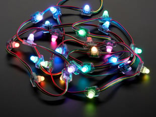 Cluster of many lit up LED pixels on wire strand, rainbow colored