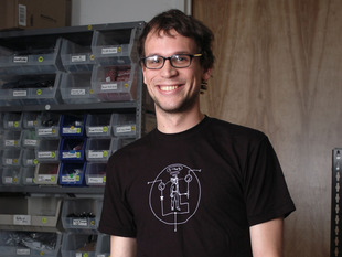 Man wearing black t-shirt with white NPN transistor diagram with a man inside the diagram