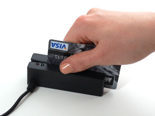 Hand sliding a credit card through reader