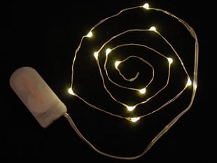 Coil of thin flexible wire with lit up embedded LED 'fairy' lights attached to battery holder