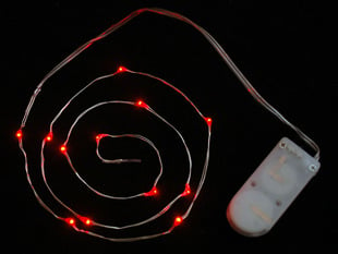 Coil of thin flexible wire with lit up embedded red LED 'fairy' lights attached to battery holder