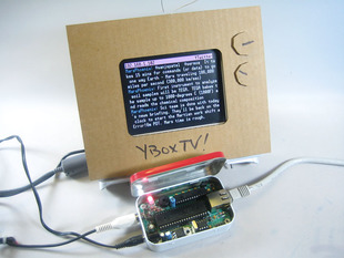 Altoid tin with YBox circuitboard inside displaying some text on a TFT dressed up like a TV set.