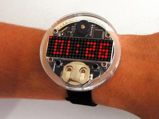 Arm with large round watch with dot matrix display showing time