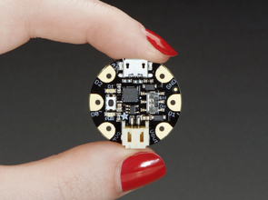 Hand with bright red manicure, holding a small red circuit board